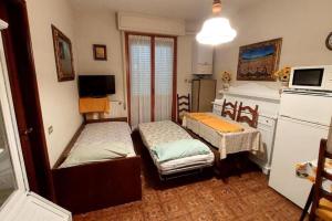 a small room with two beds and a kitchen at Il Quadrifoglio Bilocale tra Lavagna e Chiavari in Carasco
