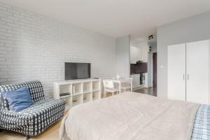 a bedroom with a bed and a tv and a chair at Chill Apartments Studio in Warsaw