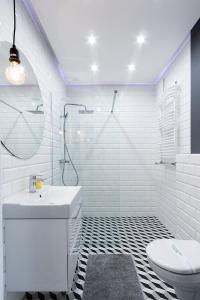 B&M - By The Sea Apartments Batorego 7 في غدينيا: حمام أبيض مع حوض ومرحاض