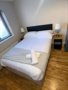 een slaapkamer met een bed met twee handdoeken erop bij Cosy 4 Bedroom Galway House with Rear Garden Patio in Galway