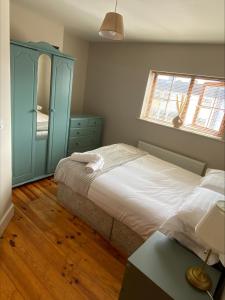 a bedroom with a bed and a blue cabinet at Cosy 4 Bedroom Galway House with Rear Garden Patio in Galway