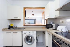 a kitchen with a washing machine and a microwave at Home2Book Charming Studio Santa Cruz City Views in Santa Cruz de Tenerife