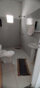 a white bathroom with a toilet and a sink at casa temporada em Barreirinhas in Marinheiros