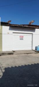 a white garage door with a sign on it at casa temporada em Barreirinhas in Marinheiros