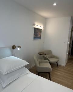 een slaapkamer met een bed en 2 stoelen en een tafel bij Le cap dagde in Cap d'Agde