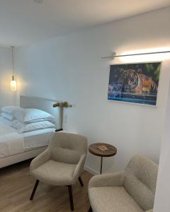 een slaapkamer met een bed, een stoel en een tafel bij Le cap dagde in Cap d'Agde
