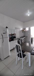 a kitchen with a table and chairs and a refrigerator at casa temporada em Barreirinhas in Marinheiros
