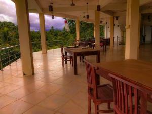 ein Restaurant mit Tischen und Stühlen und einem Balkon in der Unterkunft Red Letter Hotel in Kandy