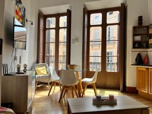 - un salon avec une table et des chaises dans l'établissement MacGregor Apartment, à Malaga