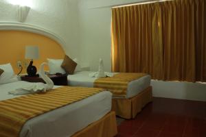 En eller flere senge i et værelse på Hotel Antillano