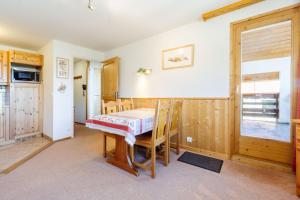 a dining room with a table and a kitchen at le plein soleil méribel mottaret in Les Allues +12 photos