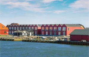 a row of colorful buildings next to a body of water at Beautiful Home In Ulfborg With House Sea View in Thorsminde