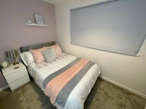 - une chambre avec un lit et un mur blanc dans l'établissement Silver Stag Properties, Cozy 2 BR Home w Parking, à Loughborough
