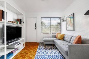 uma sala de estar com um sofá e uma televisão de ecrã plano em Fitzroy North Boutique Bliss by Merri Creek Trail em Melbourne