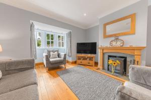 a living room with a fireplace and a tv at Springbank Cottage, luxury Lake District cottage in Coniston in Coniston