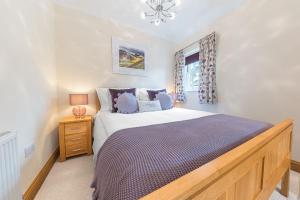 ein Schlafzimmer mit großem Bett und Fenster in der Unterkunft Springbank Cottage, luxury Lake District cottage in Coniston in Coniston
