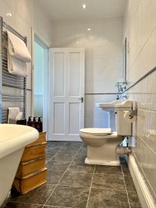 Baño blanco con aseo y lavamanos en Coed Mawr Hall Bed & Breakfast en Conwy