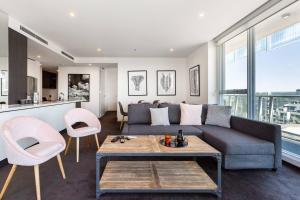 a living room with a couch and a table and chairs at City View Chic in South Yarra with Parking in Melbourne