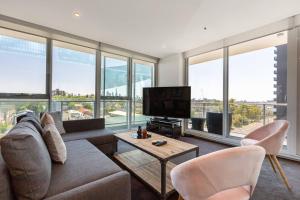 a living room with a couch and chairs and windows at City View Chic in South Yarra with Parking in Melbourne