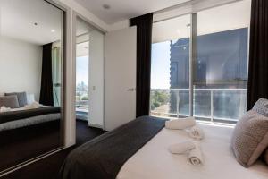 sypialnia z dużym łóżkiem i dużym oknem w obiekcie City View Chic in South Yarra with Parking w Melbourne