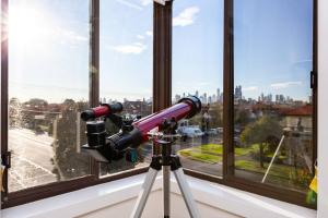 un telescopio en un trípode frente a una ventana en 'The Lighthouse' Character-filled Abode near Beach, en Melbourne
