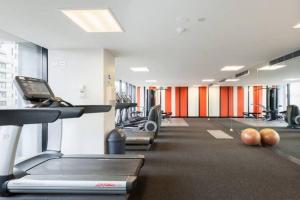 a gym with rows of treadmills and machines at Modern Cosmopolitan Retreat on Toorak Rd in Melbourne