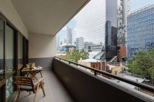 a balcony with a table and a view of a city at Spacious Inner-city Stay with King Bed and Balcony in Melbourne
