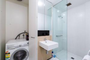 Un baño con lavadora y lavabo. en Southside St Kilda Seclusion with Balcony and Parking, en Melbourne 5 fotos más