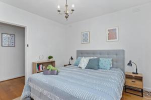 a bedroom with a large bed with a blue comforter at Enjoy The Esplanade's Treats From Acland Street in Melbourne