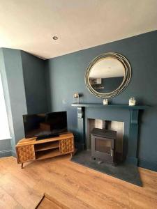 a living room with a mirror and a fireplace at Central Newquay Terrace House in Newquay