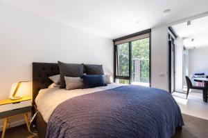 ein Schlafzimmer mit einem großen Bett und einem großen Fenster in der Unterkunft Richmond Chic off Bridge Rd with Patio Parking in Melbourne