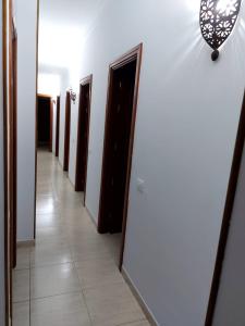 einen Flur mit einer Reihe von Türen und einem Spiegel in der Unterkunft NIVARIA SUITE in Vecindario