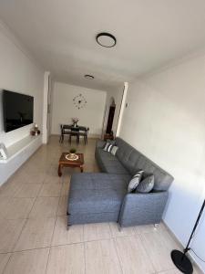 Sala de estar con sofá gris y mesa en NIVARIA SUITE en Vecindario