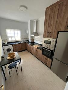 a large kitchen with a table and a refrigerator at NIVARIA SUITE in Vecindario