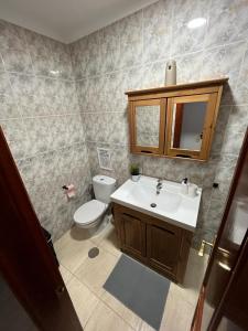 a bathroom with a white toilet and a sink at NIVARIA SUITE in Vecindario