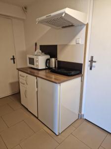 a small kitchen with a microwave and a stove at Penzion ALICE in Zlín