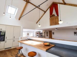 a kitchen with white cabinets and a wooden counter top at The Chapel in Alfreton
