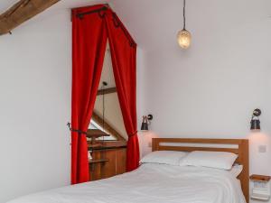 a bedroom with a window with red curtains at The Chapel in Alfreton