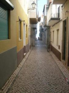 un vicolo con una strada di ciottoli in una città di Apartamentos das Avós-Flor a Nazaré