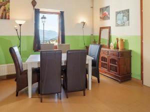 a dining room with a table with chairs and a mirror at Traditional Apartment in Poffabro with Fireplace in Frisanco