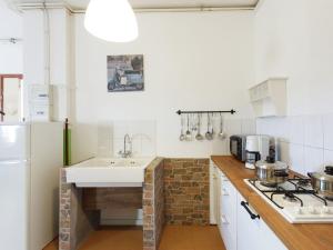 a white kitchen with a sink and a stove at Traditional Apartment in Poffabro with Fireplace in Frisanco