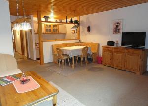 a living room with a table and a tv at Feriendorf Reichenbach - Bgm.-Martin-Str. 11a/3 in Nesselwang +22 photos