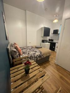 a small room with a bed and a bench in it at Wonderful fully-equipped studio near Central London in London