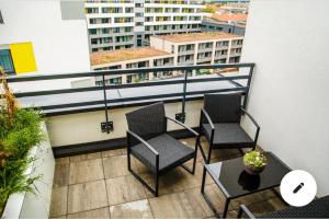 a balcony with chairs and a table and a building at The Town Hall Residence -Welcome Home Apartment-free outdoor parking-AC in Košice