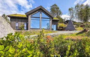ein Haus auf einem Hügel mit einem großen Fenster in der Unterkunft Nice Home In Edland With Wifi in Botn