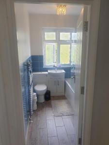 a bathroom with a toilet and a sink and a window at double room in Thornton Heath