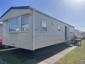 a silver trailer is parked in a yard at 2 Bedroom Caravan - Ash 51, Trecco Bay in Newton
