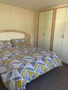 1 dormitorio con 1 cama de color azul en 2 Bedroom Caravan - Ash 51, Trecco Bay, en Newton