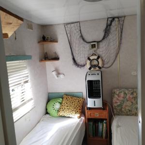 Aurec-sur-Loire的住宿－mobile home aux Rives D'Aurec，小卧室配有一张床和一张桌子上的电话