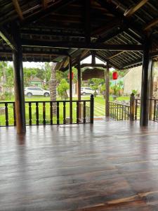 a pavilion with a wooden floor and cars in a park at Highland garden - homestay Phú Yên 